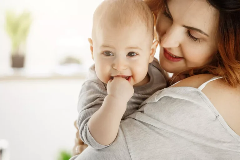 close up cute little baby mother hands mom looking child with love care while kid gnawing hand smiling camera family concept 69d6c70dbd870